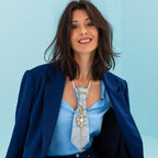 Claudia De Rosa indossa Cravatta Gioiello Blue & Gold Cross in tessuto azzurro con charm a croce dorata e collana perle + catena gold, completo tailleur blu di velluto