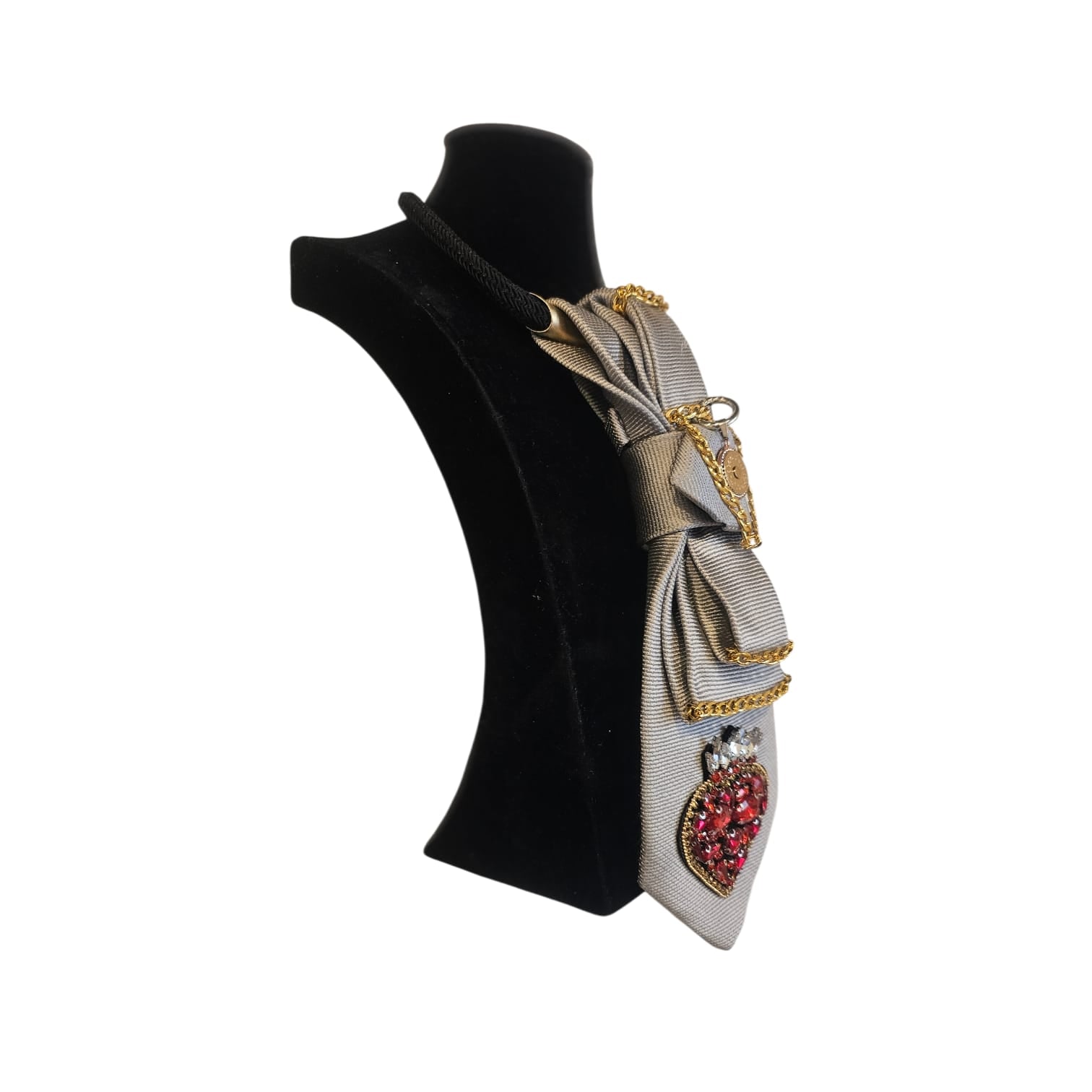Cravatta gioiello donna componibile grigio chiaro con cuore ex voto rosso, strass e catene metalliche su manichino posizione laterale verso sinistra