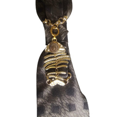 Dettaglio nodo cravatta gioiello Mystic Fish Gold con charm a forma di lisca di pesce di colore oro
