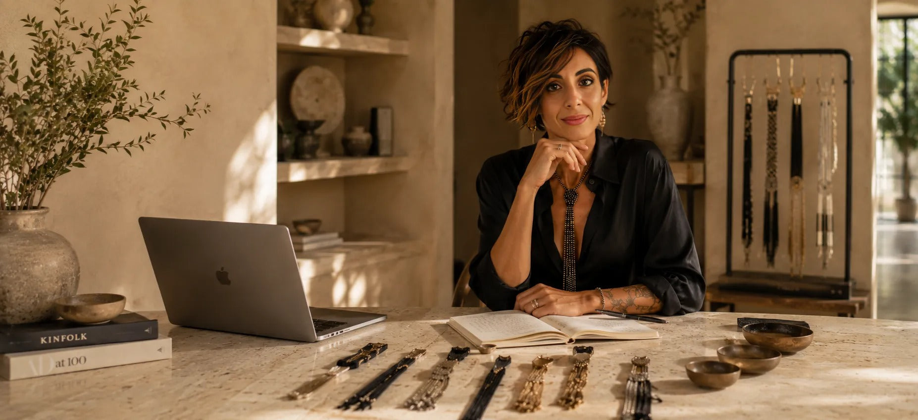 Claudia De Rsa nel suo laboratorio con cravatte sulla scrivania e pc aperto